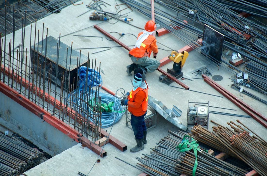 Construction workers fixing steel reinforcement on a concrete slab