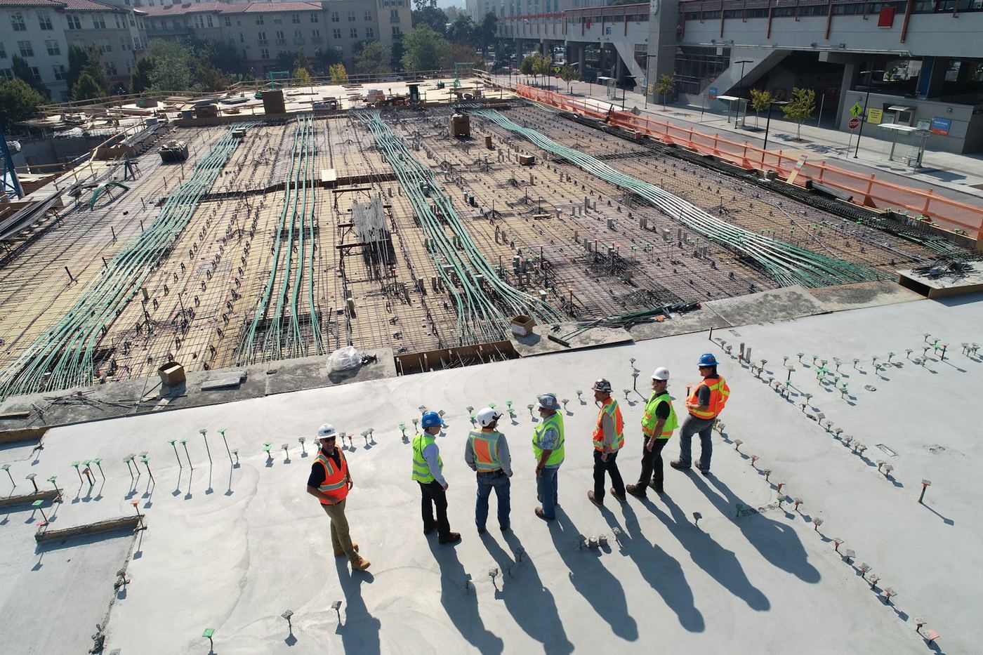 Engineers in safety vests reviewing a construction site from above