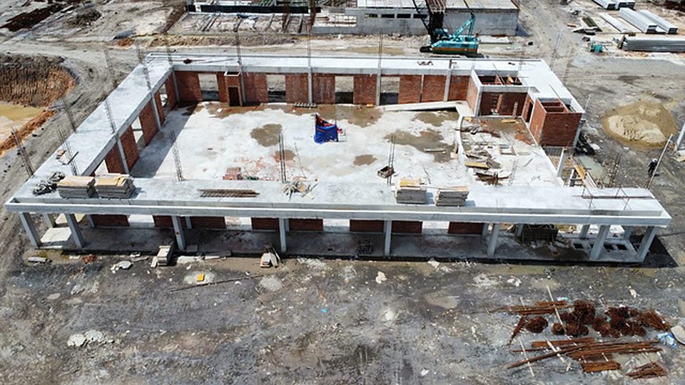 Aerial view of a single-storey block with brickwork and roof slab in progress
